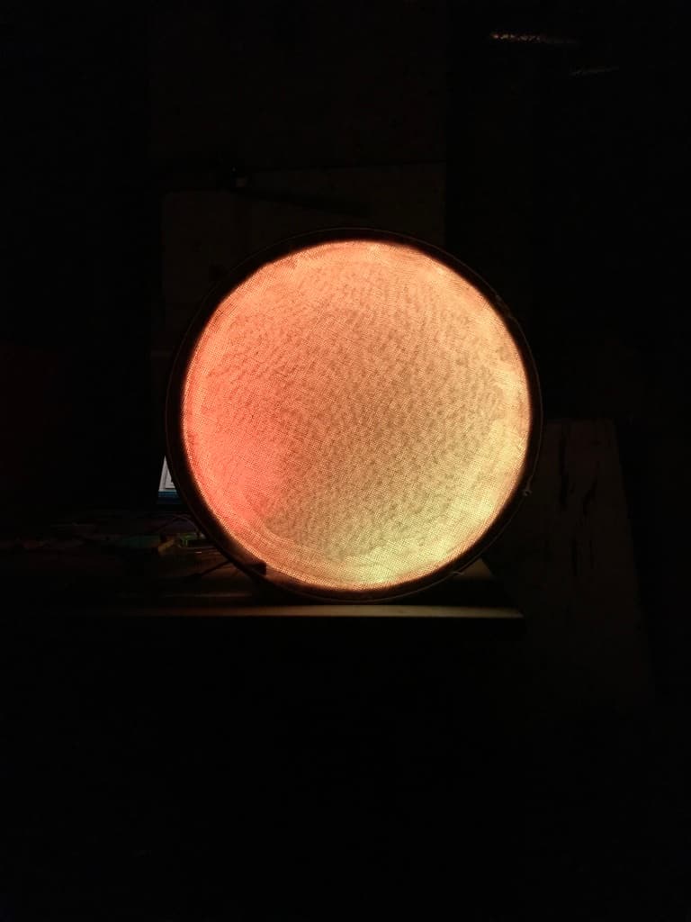 Jumi Käse Installation 2018 - First prototype 2 A circled shaped object that diffuses orange LED lights coming from inside of the object